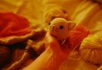 Crocheted cat head beside yarn balls; illustrative image for crochet cat projects