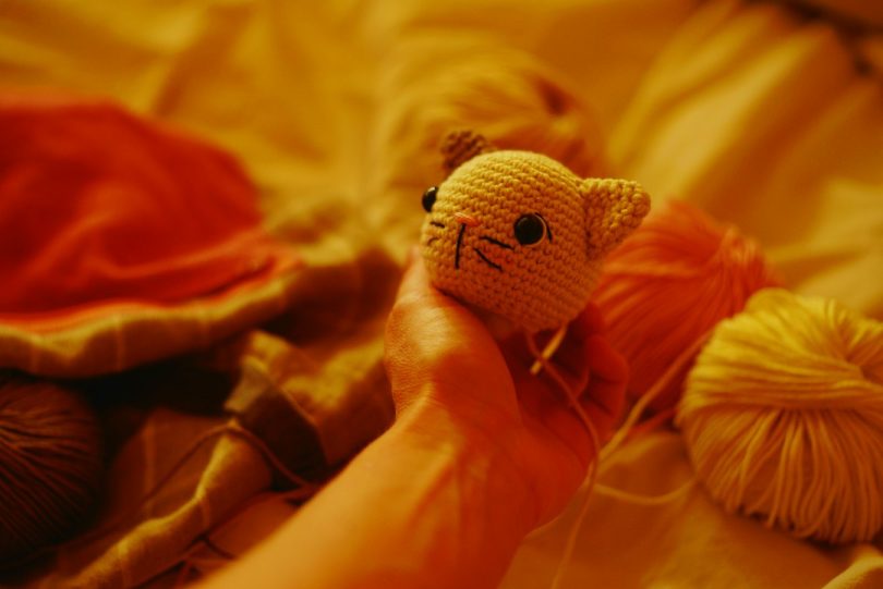 Crocheted cat head beside yarn balls; illustrative image for crochet cat projects