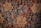 Brown crocheted lace fabric with floral motifs