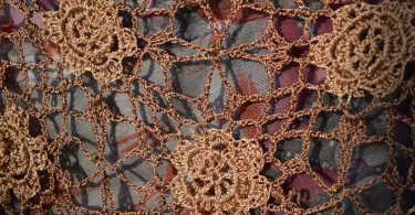 Brown crocheted lace fabric with floral motifs