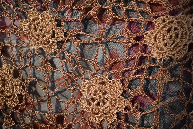 Brown crocheted lace fabric with floral motifs