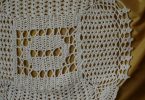 White crocheted lace motif illustrating filet crochet chartwork