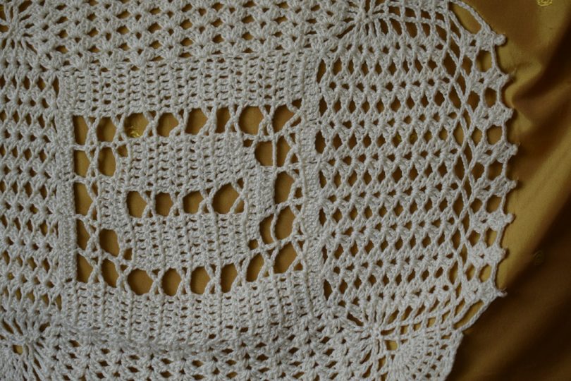 White crocheted lace motif illustrating filet crochet chartwork