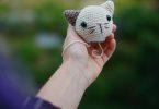 Small handmade crocheted cat head held in a hand; illustrative crochet image