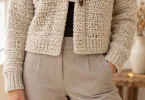 Oatmeal textured cropped crochet cardigan with rolled collar and toggle fastening styled over a dark top